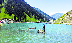 A boy jumps into a freshwater lake in Sonmarg