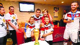 Miroslav Klose celebrates the win with Germany Chancellor Angela Merkel and his kids