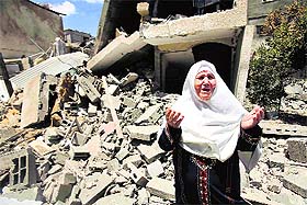 A Palestinian woman reacts in front of the remains of her house in Rafah in the southern Gaza Strip on Monday. 