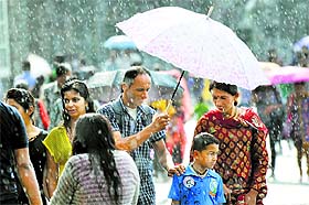 People walk with umbrellas during rain in Shimla on Tuesday