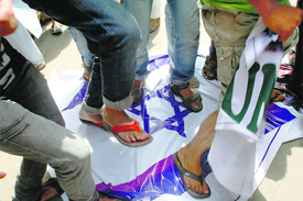 youths stomp on the Israeli flag in Srinagar on Tuesday.