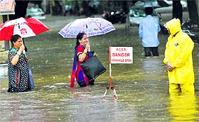 People walk through a flooded street after heavy rain in Mumbai on Tuesday.