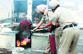 Controlling flames: Fire brigade workers try to douse flames at HDB Financial Services office on GT Road in Bathinda on Wednesday. 