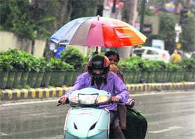 Ride in the rain: A couple ventures out in the monsoon showers in Dehradun on Wednesday
