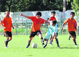 Players try to take control of the ball in a match in the Nemidas Memorial District Football League played at Pavilion Ground in Dehradun on Wednesday