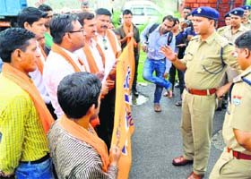 Policemen try to pacify members of the Bajrang Dal during their protest at the Nehru Colony police station in Dehradun on Wednesday