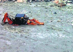 A JCB machine that was washed away in the Asi Ganga river, near Gangori village, in Uttarkashi on Tuesday evening