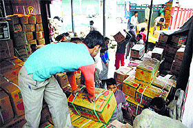 Workers load apple boxes on trucks in Shimla.