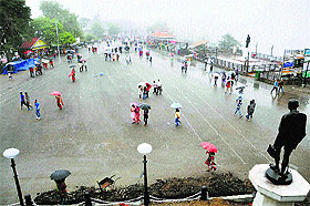 People walk with umbrellas during a downpour in Shimla on Wednesday.