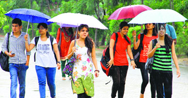 Girls enjoy rain on university campus near Jalandhar on Wednesday.