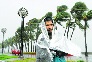 A man walks through heavy wind and rain as Typhoon Rammasun barrels across Manila on Wednesday