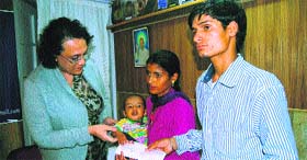Dr Venu Sanon, member of the Divine Light Trust, presents a cheque for Rs 65,000 to the parents of the child scheduled to go through heart surgery at Ganga Ram Hospital in Mussoorie on Thursday.