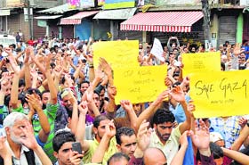 Protesters raise slogans during a strike call given by hardline Hurriyat Conference chief Syed Ali Shah Geelani against the attacks on Gaza, in Anantnag on Thursday