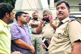 A police officer speaks to Sunil Garg, who was kidnapped and robbed, on the phone in Ludhiana on Thursday