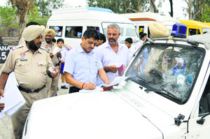 Anil Garg, DTO, challans a school van in Ludhiana on Thursday. 