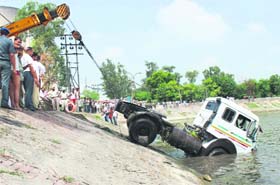 A truck that plunged into the lake being taken out with the help of a crane near the thermal plant in Bathinda on Friday.