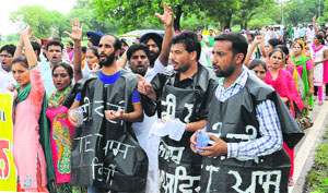 Teachers beg on a street during their protest at Phase VIII in Mohali on Friday. 