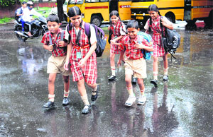 Schoolchildren run for cover during rain in Chandigarh on Friday.