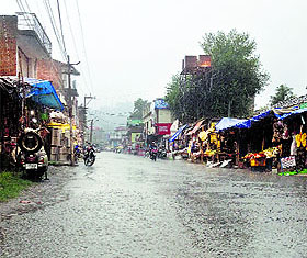 A road wears a deserted look after rain in Kangra on Friday.