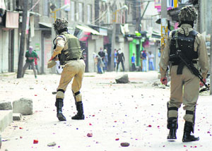 Youths throw stones at security personnel during a protest against Israeli military operations in Gaza, in Srinagar on Friday. 