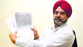 Brig Nawab Singh Heer (retd) shows alleged fake documents used by the accused to sell his plot.