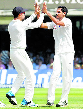 Virat Kohli and Bhuvneshwar Kumar celebrate the wicket of Alastair Cook during the second day at Lords in London on Friday.