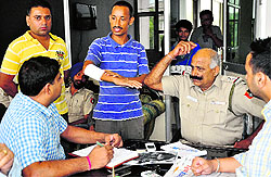 Ravi Kumar and Japinder (both standing) narrate the robbery incident to the police in Mohali on Saturday