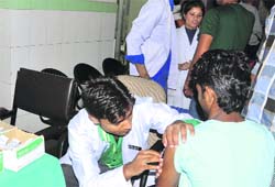 Doctors shift outside the injection room due to stench emanating from a leakage from the drain at Doon Hospital on Saturday. A Tribune photograph