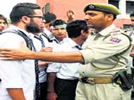 a policeman stops student protesters on Saturday.