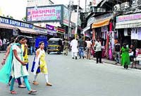 People walk in Raghunath Bazaar during a shutdown call in Jammu on Saturday. 
