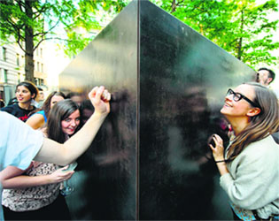 Once sealed inside, members of the public (right) could press their ears to the outside to hear the heavily muted music through the sound-proofed casing.