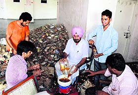 Officials of the Excise Department drain out the seized liquor at the District Administrative Complex in Bathinda on Sunday.