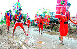 Devotees tread a muddy Kanwar track after fetching the Ganga water from Har-ki-Pauri and Ganga ghats in Haridwar on Sunday