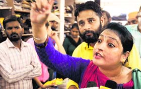 A woman argues with a shopkeeper after a hidden camera was found in a trial room of a garment store