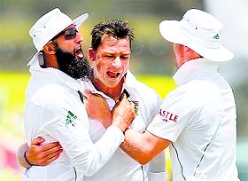 Dale Steyn (C) celebrates with captain Hashim Amla (L) and AB de Villiers after taking the wicket of Dilruwan Perera during the fifth day of the first Test in Galle on Sunday.
