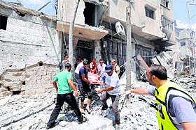 Palestinian rescuers evacuate a body following an Israeli offensive on the Shejaiya neighbourhood on Sunday