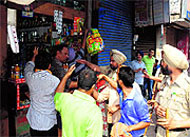 Activists force closure of shops during the Amritsar bandh call at the Hall Gate in Amritsar on Monday