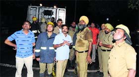 Firefighters and officials of the Directorate of Industrial Training, Haryana, outside the 30 Bays building in Sector 17, Chandigarh, late on Monday evening.