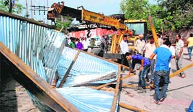 MC employees use a JCB machine to demolish an illegal liquor vend at Abheypur village in Panchkula on Monday.