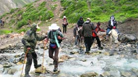 Kailash Mansarovar pilgrims are helped by ITBP janwans to cross a stream in Pithoragarh