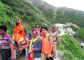 Yoga Guru Ramdev being helped by the members of the State Disaster Response Force (SDRF) during his recent visit to Gangotri