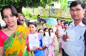 People wait for their turn to vote at Doiwala in Dehradun on Monday