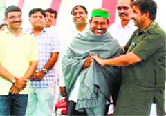 Industries Minister Mukesh Agnihotri honours Gurdial Singh, who donated land for the construction of the tourist information centre, in Kangar village on Sunday. Photo: Rajesh Sharma