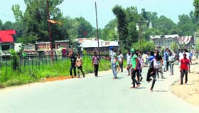 Youths throw stones at security forces (not in picture) in Kulgam district on Monday.