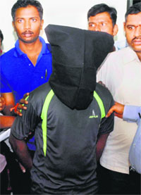 Mustafa, a skating instructor, accused of raping a girl in a school, is produced by the police at a press conference in Bengaluru on Monday