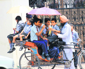 Schoolchildren try to escape the scorching sun in Bathinda on Tuesday.