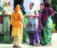 Women gather outside the house of LIC agent Vikas Balli at Sector 11, Panchkula, on Tuesday. Tribune Photo: Nitin Mittal