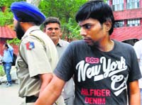 The accused, Vijay Pandey, in police custody in Chandigarh on Tuesday. Tribune photo: Vicky Gharu 