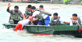 The saviours: Bengal Engineers Group Sappers save a Kanwariya from drowning during Kanwar fair in Haridwar on Tuesday.