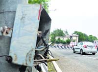 Loose wires hang from the safety board of a streetlight pole in Jammu. Tribune photo: Anand Sharma